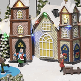 Villaggio di Natale innevato decorativo con luci