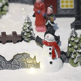Villaggio di Natale innevato decorativo con luci